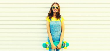 Beyaz arka planda yeşil kaykaylı gülümseyen genç bir kadının yaz portresi, reklam metinleri için boş kopya alanı