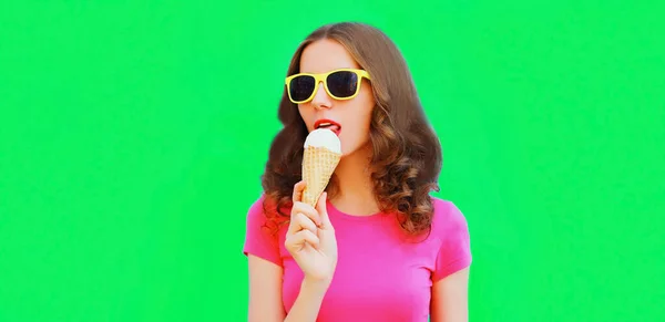 緑の背景にアイスクリームを食べる若い女性の肖像画 — ストック写真