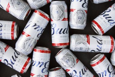 KHARKIV, UKRAINE - 1 Ağustos 2021: Birçok konserve Budweiser Alkol Birası gri arka planda yatar. Budweiser, Anheuser-Busch Inbev 'den Amerika' nın en popüler markasıdır.
