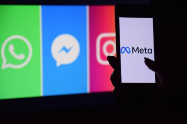 KHARKIV, UKRAINE - 4 Kasım 2021: Facebook adını Meta olarak değiştirdi. Facebook metaverse 'e ait ürünlerin logolarının arka planında Meta logosu olan akıllı telefon.