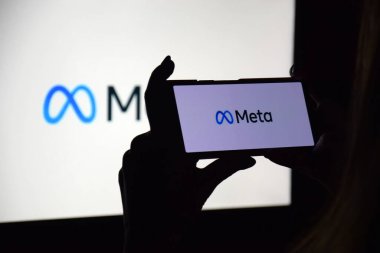 KHARKIV, UKRAINE - 4 Kasım 2021: Facebook adını Meta olarak değiştirdi. Facebook metaverse 'e ait ürünlerin logolarının arka planında Meta logosu olan akıllı telefon.