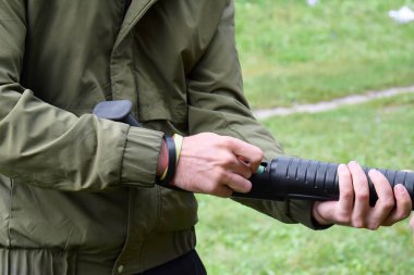 Genç bir adam tüfekle çatışma eğitimi alıyor. Uzun av tüfeği, pompalı tüfek ve pompalı tüfek. Atış galerisi