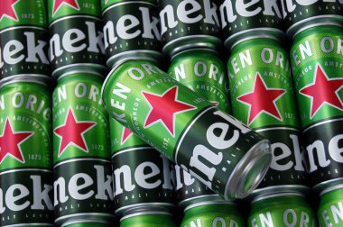 KHARKIV, UKRAINE - 1 Ağustos 2021: Birçok Heineken alkollü birası gri arka planda yatar. Heineken, Hollanda 'nın en büyük ve dünyanın en büyük ikinci bira şirketidir..
