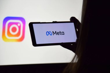 KHARKIV, UKRAINE - 4 Kasım 2021: Facebook adını Meta olarak değiştirdi. Facebook metaverse 'e ait ürünlerin logolarının arka planında Meta logosu olan akıllı telefon.