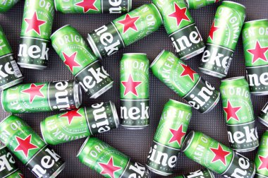 KHARKIV, UKRAINE - 1 Ağustos 2021: Birçok Heineken alkollü birası gri arka planda yatar. Heineken, Hollanda 'nın en büyük ve dünyanın en büyük ikinci bira şirketidir..