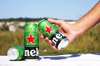 KHARKIV, UKRAINE - 1 AĞUSTOS 2021: Birçok Heineken alkollü bira kutusu manzaranın arka planında yatar. Heineken, Hollanda 'nın en büyük ve dünyanın en büyük ikinci bira şirketidir..