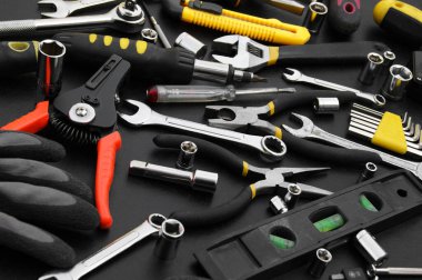 Siyah arka planda onarım için çok farklı araçlar var. Onarım ve inşaat konsepti.