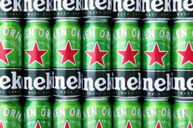 KHARKIV, UKRAINE - 1 Ağustos 2021: Birçok Heineken alkollü birası gri arka planda yatar. Heineken, Hollanda 'nın en büyük ve dünyanın en büyük ikinci bira şirketidir..