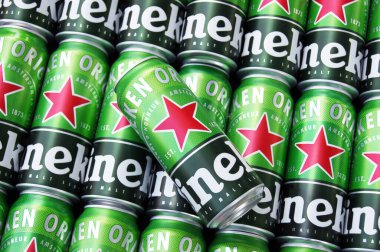 KHARKIV, UKRAINE - 1 Ağustos 2021: Birçok Heineken alkollü birası gri arka planda yatar. Heineken, Hollanda 'nın en büyük ve dünyanın en büyük ikinci bira şirketidir..