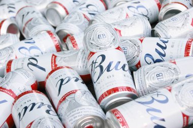 KHARKIV, UKRAINE - 1 Ağustos 2021: Birçok konserve Budweiser Alkol Birası gri arka planda yatar. Budweiser, Anheuser-Busch Inbev 'den Amerika' nın en popüler markasıdır.