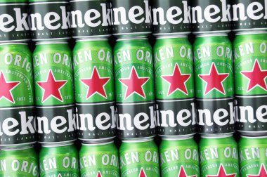 KHARKIV, UKRAINE - 1 Ağustos 2021: Birçok Heineken alkollü birası gri arka planda yatar. Heineken, Hollanda 'nın en büyük ve dünyanın en büyük ikinci bira şirketidir..
