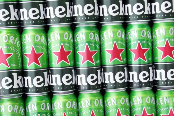 KHARKIV, UKRAINE - 1 Ağustos 2021: Birçok Heineken alkollü birası gri arka planda yatar. Heineken, Hollanda 'nın en büyük ve dünyanın en büyük ikinci bira şirketidir..