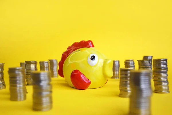 周りのコインと魚の形で黄色の貯金箱 貯蓄概念 — ストック写真