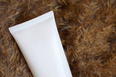 Sazlıkların arka planında krem, ovalama, yüz ve vücut losyonu. Üst Manzara. Cilt bakımı ve kozmetoloji kavramı.