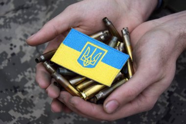 Kirli erkek elleri üstünde Ukrayna pasaportu olan mermi kovanlarını tutuyor. Ukrayna 'da savaş. Savaşı durdurun..