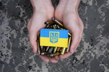 Kirli erkek elleri üstünde Ukrayna pasaportu olan mermi kovanlarını tutuyor. Ukrayna 'da savaş. Savaşı durdurun..