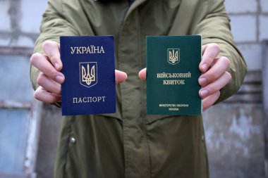 Ukrainian military ID, passport in the hands of a young guy. War in Ukraine. Stop the war. clipart