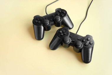 Sarı arka planda iki oyun kumandası. Minimalizm. Oyun konsepti.