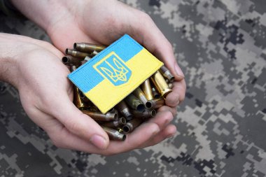 Kirli erkek elleri üstünde Ukrayna pasaportu olan mermi kovanlarını tutuyor. Ukrayna 'da savaş. Savaşı durdurun..