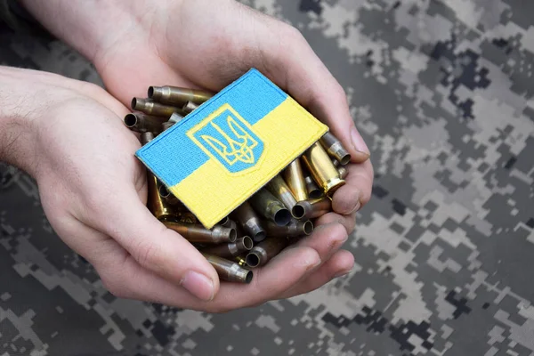 Kirli erkek elleri üstünde Ukrayna pasaportu olan mermi kovanlarını tutuyor. Ukrayna 'da savaş. Savaşı durdurun..