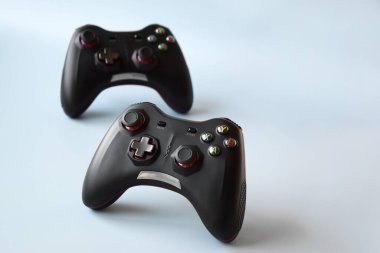 Açık mavi arka planda iki oyun kumandası. Minimalizm. Oyun, akış ve esport kavramı.