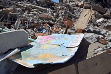 Kharkiv, Ukraine - May 7, 2022: a geography textbook for grade 9 against the backdrop of a bombed-out school in the city of Kharkov. The results of the war. War in Ukraine.