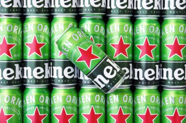 KHARKIV, UKRAINE - 1 Ağustos 2021: Birçok Heineken alkollü birası gri arka planda yatar. Heineken, Hollanda 'nın en büyük ve dünyanın en büyük ikinci bira şirketidir..