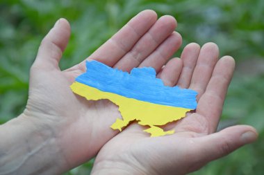 Ukrayna 'nın ulusal bayrağı gibi mavi ve sarıyla süslenmiş bir kadın elinde Ukrayna' nın ana hatlarını tutuyor. Bağımsızlık, bayrak, Anayasa Günü. Ukrayna 'da Savaş.
