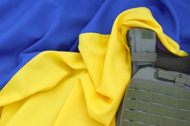 Ukrayna bayrağının arka planında plakası olan taktik ve askeri zırh. Ukrayna 'daki savaşta vücudunu kurşunlardan koruma kavramı.