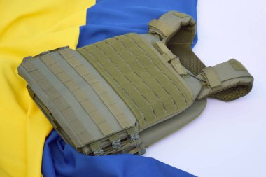 Ukrayna bayrağının arka planında plakası olan taktik ve askeri zırh. Ukrayna 'daki savaşta vücudunu kurşunlardan koruma kavramı.