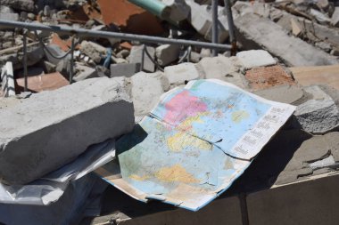 Kharkiv, Ukraine - May 7, 2022: a geography textbook for grade 9 against the backdrop of a bombed-out school in the city of Kharkov. The results of the war. War in Ukraine.