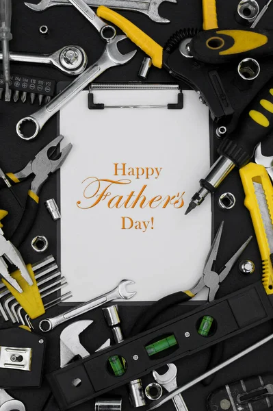 Lettering Happy Father\'s Day with many different tools for repair work on a black table. Father\'s day concept.