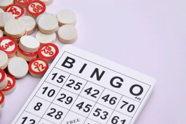 Masa başı bingo ya da loto oynamak için arka planda numaraları ve kartları olan bir sürü tahta fiş. Rus Lotosu 'nun dünya çapında klasik bingo oyunlarına benzer kuralları vardır..