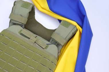 Ukrayna bayrağının arka planında plakası olan taktik ve askeri zırh. Ukrayna 'daki savaşta vücudunu kurşunlardan koruma kavramı.