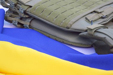 Ukrayna bayrağının arka planında plakası olan taktik ve askeri zırh. Ukrayna 'daki savaşta vücudunu kurşunlardan koruma kavramı.