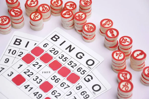 Masa başı bingo ya da loto oynamak için arka planda numaraları ve kartları olan bir sürü tahta fiş. Rus Lotosu 'nun dünya çapında klasik bingo oyunlarına benzer kuralları vardır..