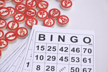 Masa başı bingo ya da loto oynamak için arka planda numaraları ve kartları olan bir sürü tahta fiş. Rus Lotosu 'nun dünya çapında klasik bingo oyunlarına benzer kuralları vardır..