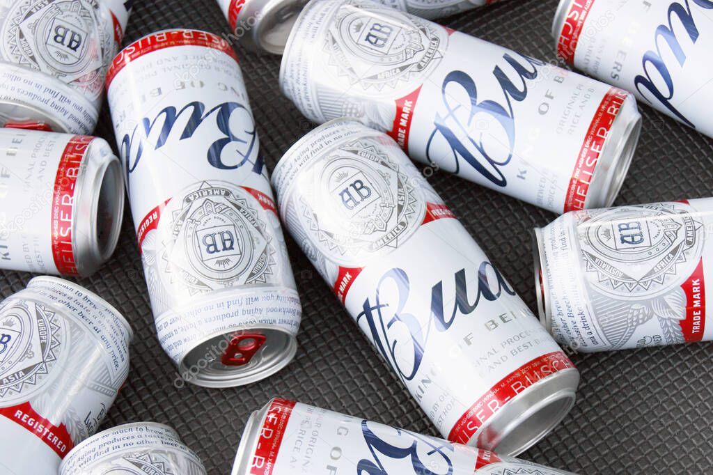 KHARKIV, UKRAINE - AUGUST 1, 2021: Many Cans of Budweiser Lager Alcohol Beer lies on grey background. Budweiser is Brand from Anheuser-Busch Inbev most popular in America
