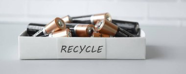 KHARKIV, UKRAINE - 22 Şubat 2022: Kullanılmış AA bataryalar ve çevresel ve toprak zehirli bataryaların mavi arka planda düzgün bir şekilde imha edilmesi. Zararlı ve geri dönüşümlü nesnelerin işlenmesi kavramı.