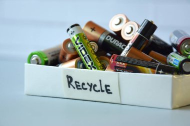 KHARKIV, UKRAINE - 22 Şubat 2022: Kullanılmış AA bataryalar ve çevresel ve toprak zehirli bataryaların mavi arka planda düzgün bir şekilde imha edilmesi. Zararlı ve geri dönüşümlü nesnelerin işlenmesi kavramı.