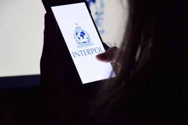 Kharkiv, Ukrayna - 16 Haziran 2022: İnterpol logosu ekranda gösterilen akıllı telefonu tutan kişi. Uluslararası Suç Polis Örgütü veya Interpol.