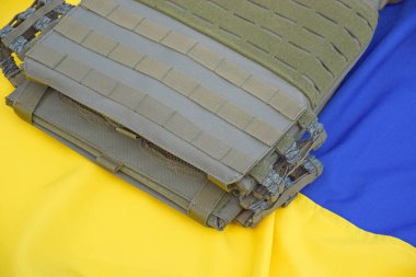 Ukrayna bayrağının arka planında plakası olan taktik ve askeri zırh. Ukrayna 'daki savaşta vücudunu kurşunlardan koruma kavramı.
