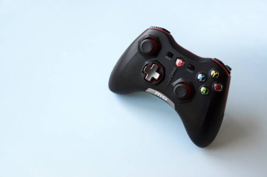 Kharkiv, Ukrayna - 21 Şubat 2022: Açık mavi arka planda iki MSI oyun kumandası. Minimalizm. Oyun, akış ve esport kavramı.