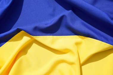 Ukrayna 'nın ulusal bayrağını büktü. Mavi ve sarı renkler. Yakın plan, arkaplan.