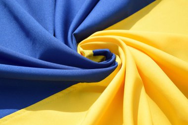 Ukrayna 'nın ulusal bayrağını büktü. Mavi ve sarı renkler. Yakın plan, arkaplan.