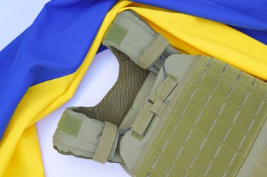 Ukrayna bayrağının arka planında plakası olan taktik ve askeri zırh. Ukrayna 'daki savaşta vücudunu kurşunlardan koruma kavramı.