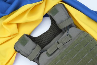 Ukrayna bayrağının arka planında plakası olan taktik ve askeri zırh. Ukrayna 'daki savaşta vücudunu kurşunlardan koruma kavramı.