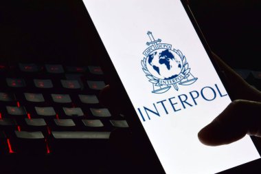 Kharkiv, Ukrayna - 16 Haziran 2022: İnterpol logosu ekranda gösterilen akıllı telefonu tutan kişi. Uluslararası Suç Polis Örgütü veya Interpol.