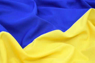 Ukrayna 'nın ulusal bayrağını büktü. Mavi ve sarı renkler. Yakın plan, arkaplan.
