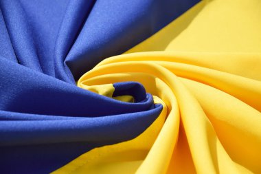 Ukrayna 'nın ulusal bayrağını büktü. Mavi ve sarı renkler. Yakın plan, arkaplan.